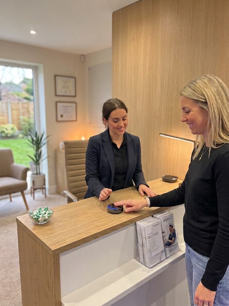 A person placing a fingertip on the Prysm iO scanner at a reception desk